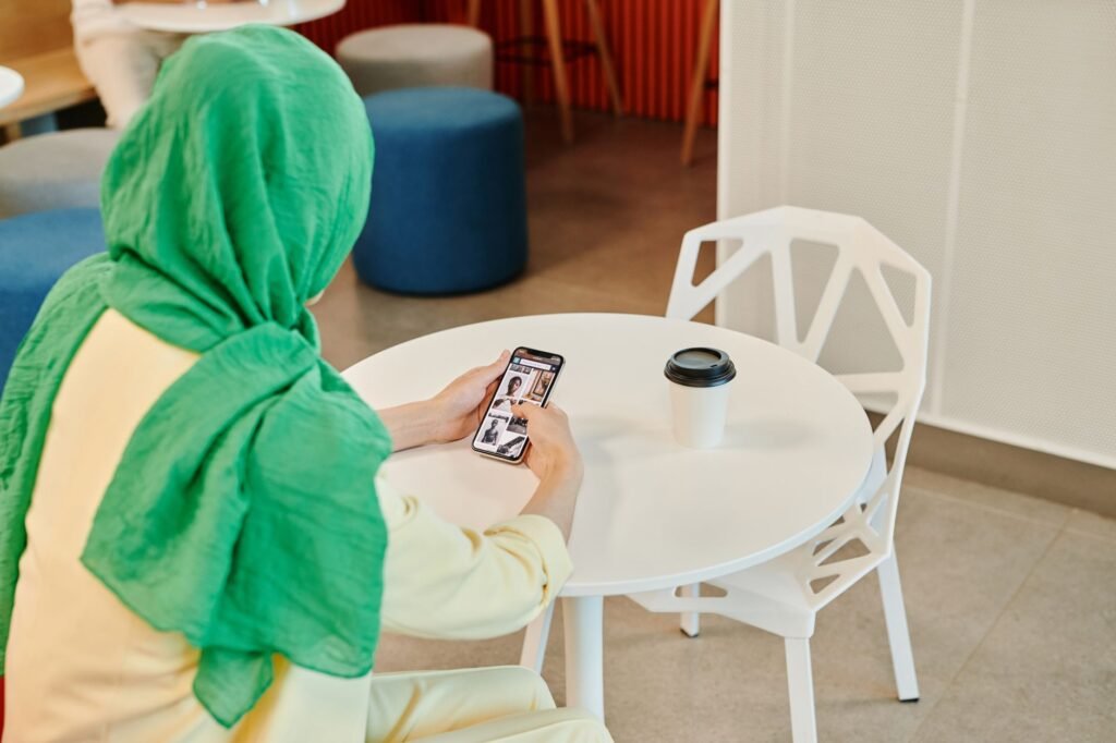 Hands holding a smartphone while browsing an app in a cafe