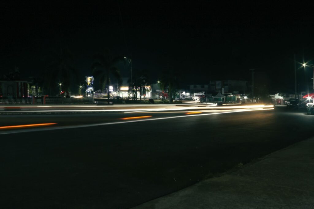 Urban night scene capturing car light trails on a busy street.