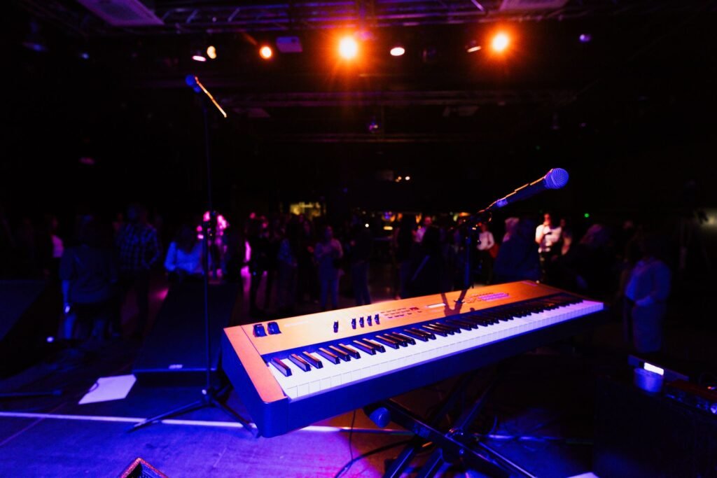 Dimly lit live music stage in Kumasi with warm amber lighting before a set begins
