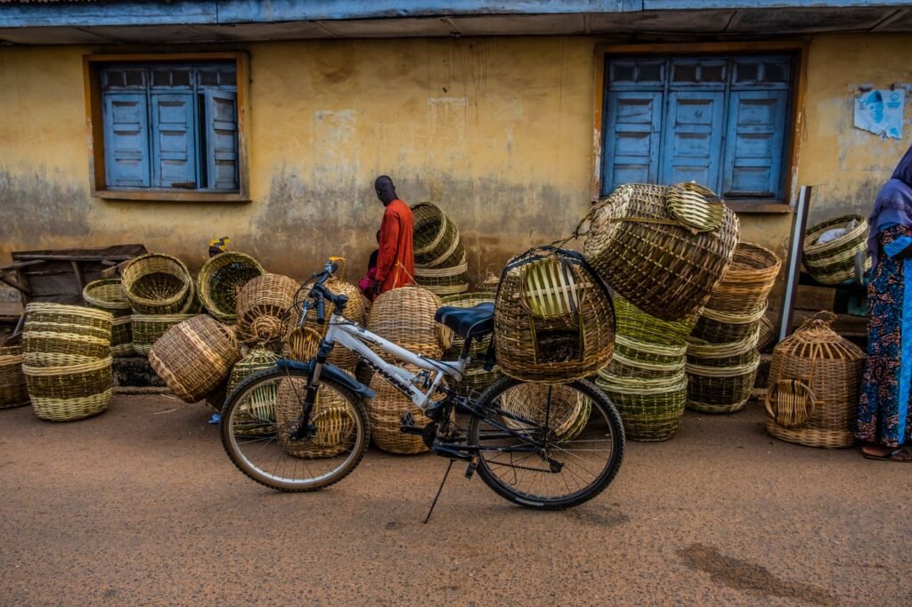 Vibrant market scene in Ifon-Osun, Nigeria with woven baskets and a bicycle.