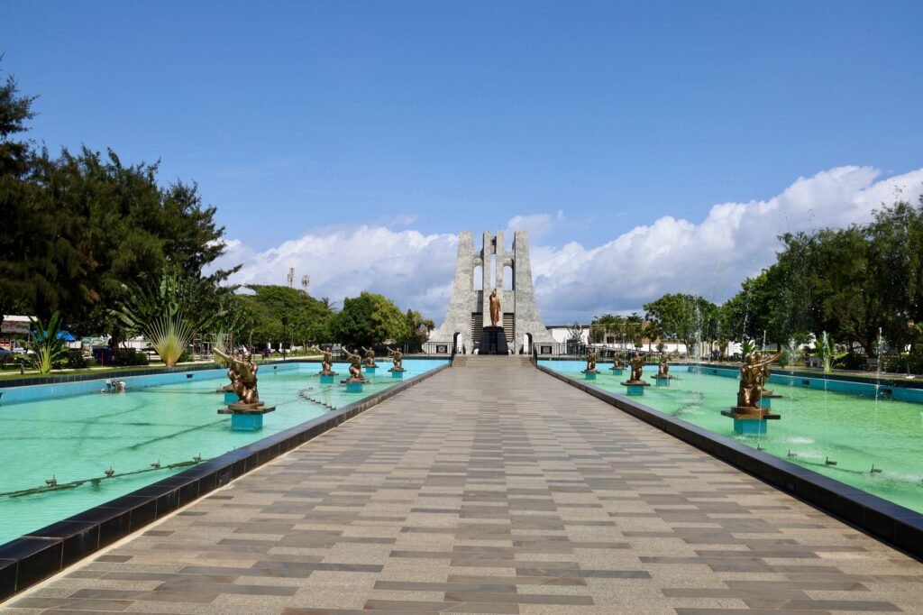 Idyllic view of the Kwame Nkrumah Memorial Park with statues and fountains under a clear blue sky in Accra, Ghana.
