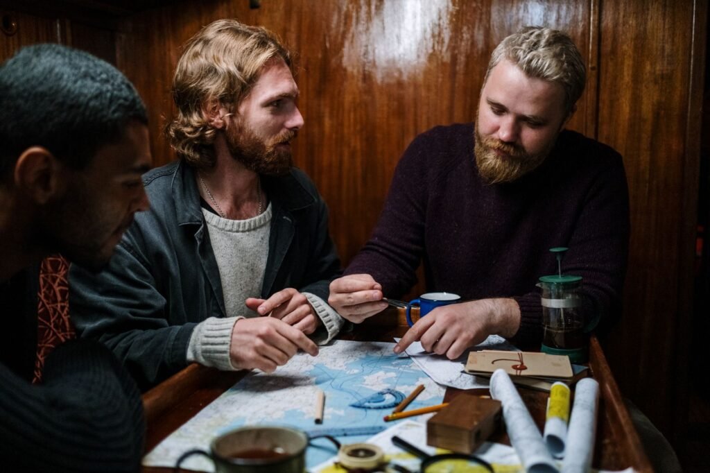 Hand tracing a route on a map beside a notebook and cup of tea