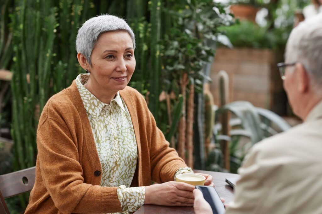 Two adults in conversation at an outdoor cafe table