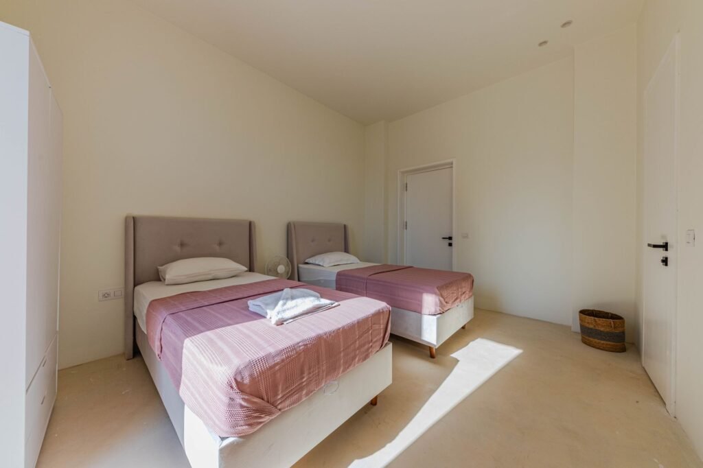 Tidy shared bedroom with two single beds in daylight