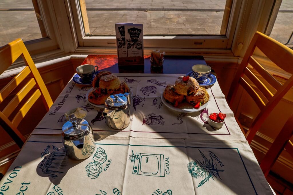 Two cups of tea on a table by a window in the late afternoon