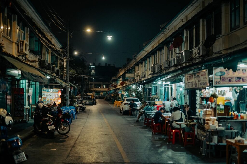 A lively scene of an Asian street market at night, showcasing local vendors and diners.