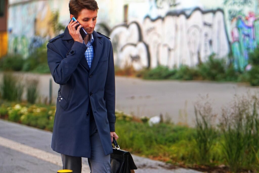 man, communication, cellphone, smartphone, briefcase, sidewalk, street, graffiti, briefcase, briefcase, briefcase, briefcase,