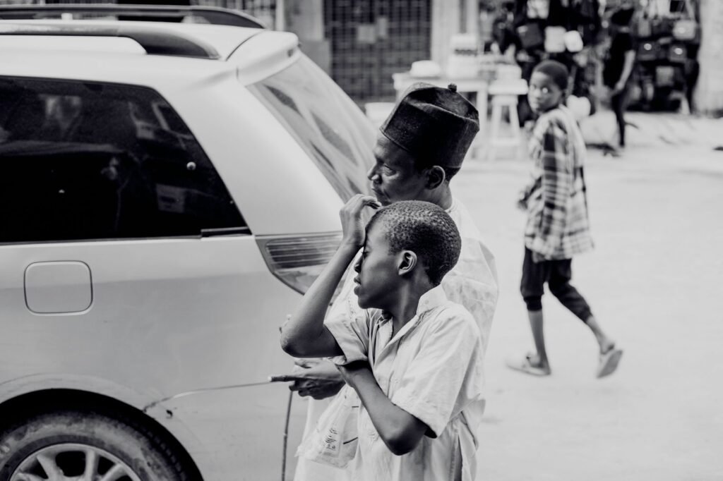 Captivating black and white street scene featuring pedestrians and a vehicle, conveying urban dynamics.
