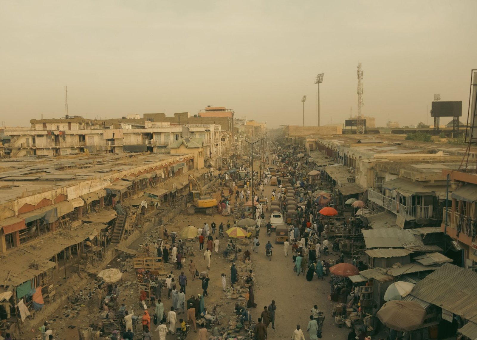 Aerial view of a crowded street market in an African city, showcasing vibrant urban life.