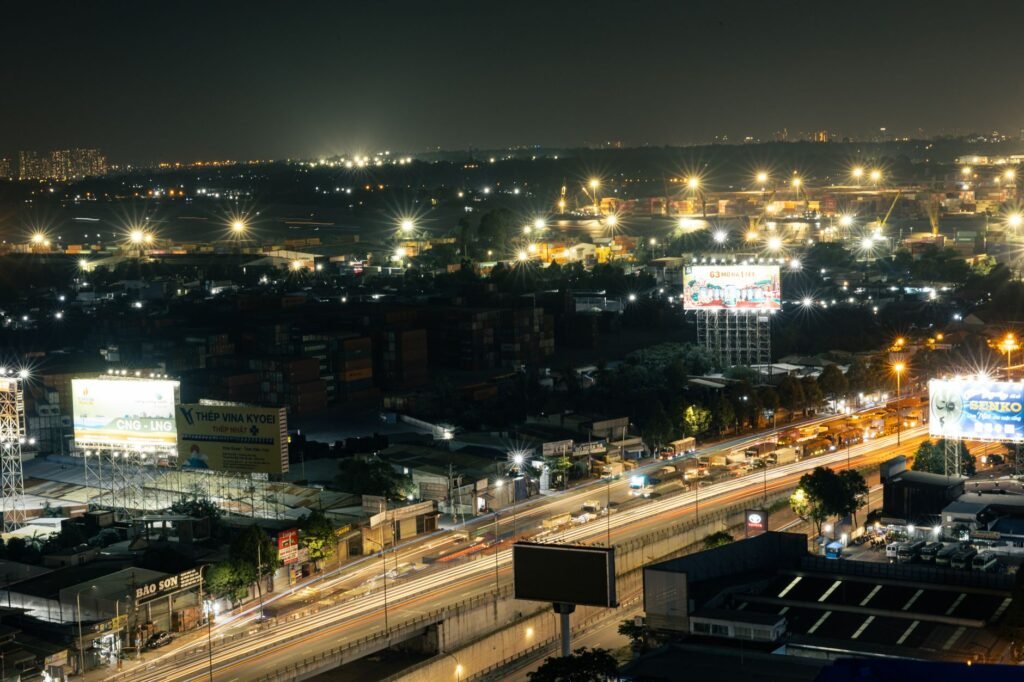 A vibrant aerial night shot of a city highway illuminated with bright lights, showcasing dynamic city life.