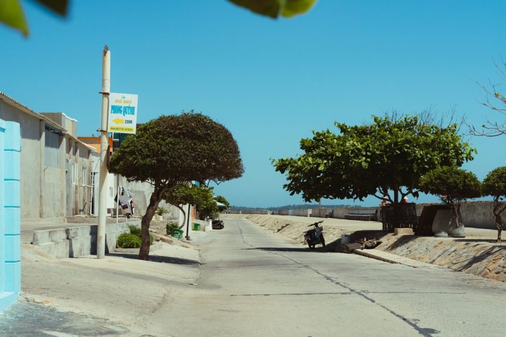 Tranquil coastal street scene in Bình Thuận, Vietnam, capturing sunny weather and local architecture.