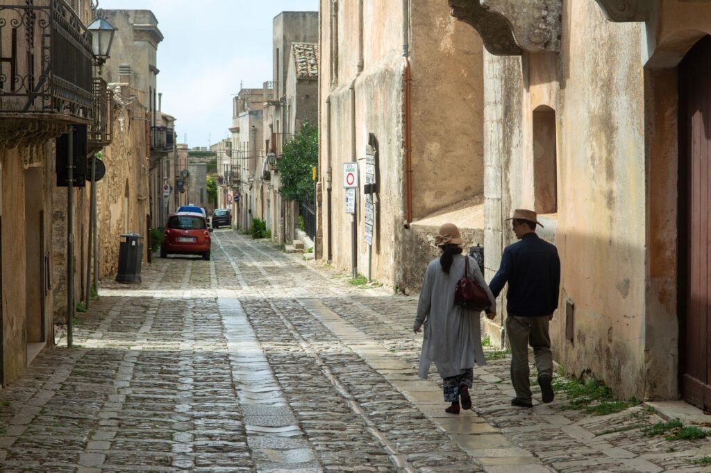 Couple walking through the cobblestone streets of Erice, Sicily, Italy.