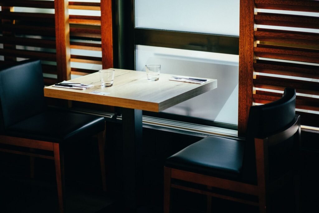 Simple table for two by a window, representing the first stop of a low-pressure date