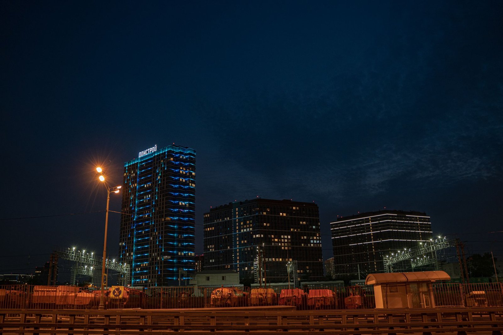 Capture of a city skyline at night with modern illuminated buildings and a clear sky.