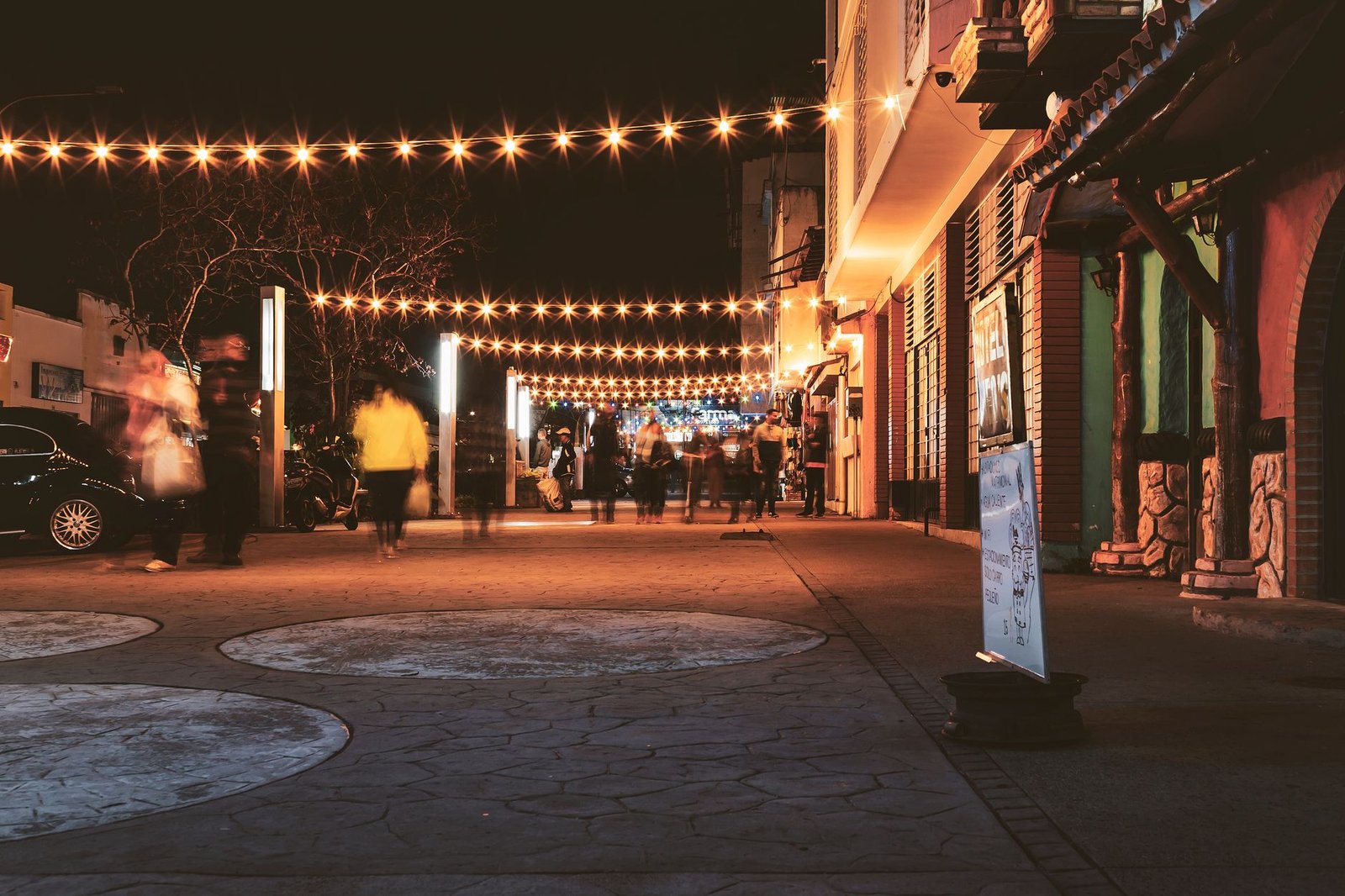 Explore the lively nightlife of Mérida, Venezuela, with bustling streets and bright string lights.