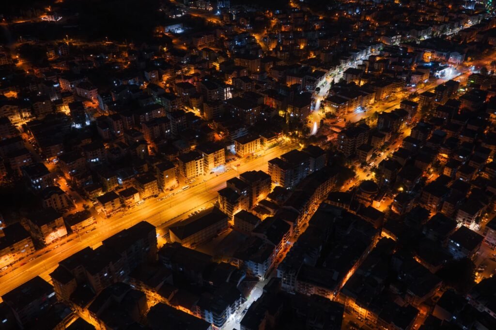 A captivating aerial view of city streets glowing with streetlights at night, showcasing urban life.