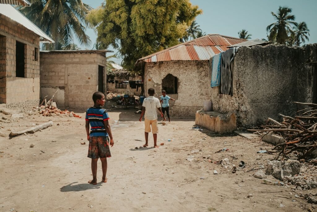Children playing in a sandy street in Zanzibar, Tanzania. Rustic village scene.