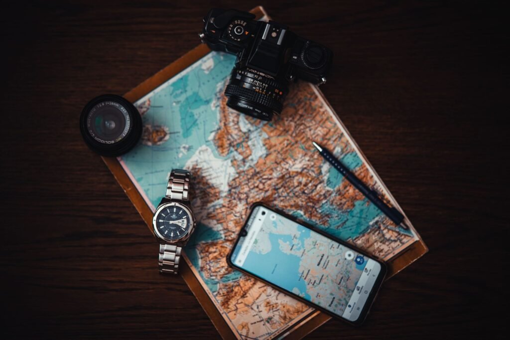 Visitor planning travel details with a map and smartphone at a desk