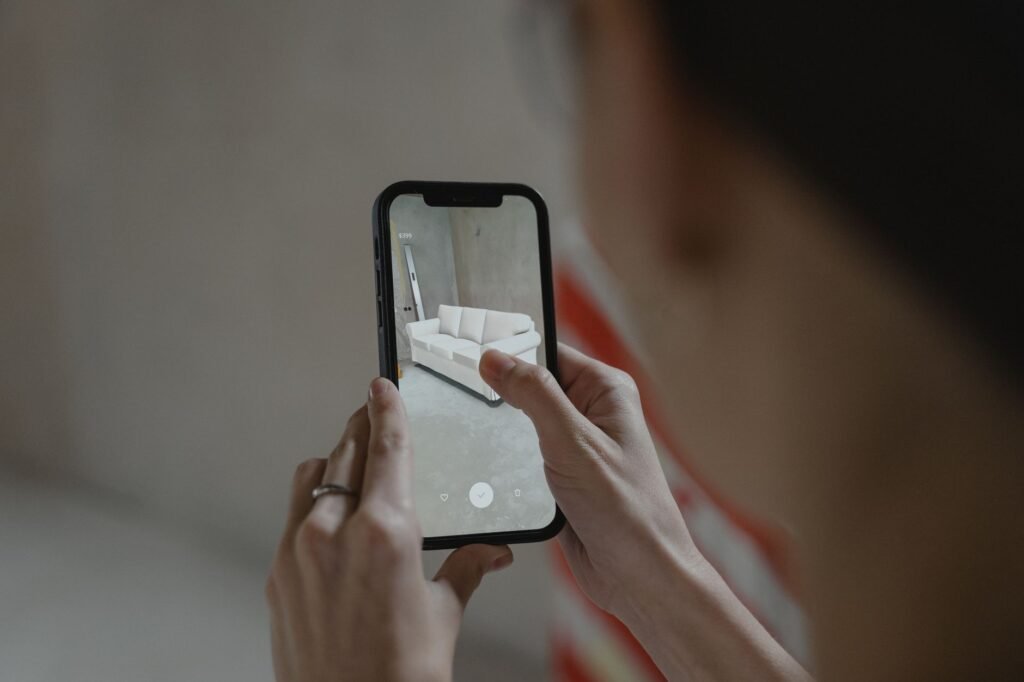 Hands holding a smartphone in a softly lit living room while checking a profile