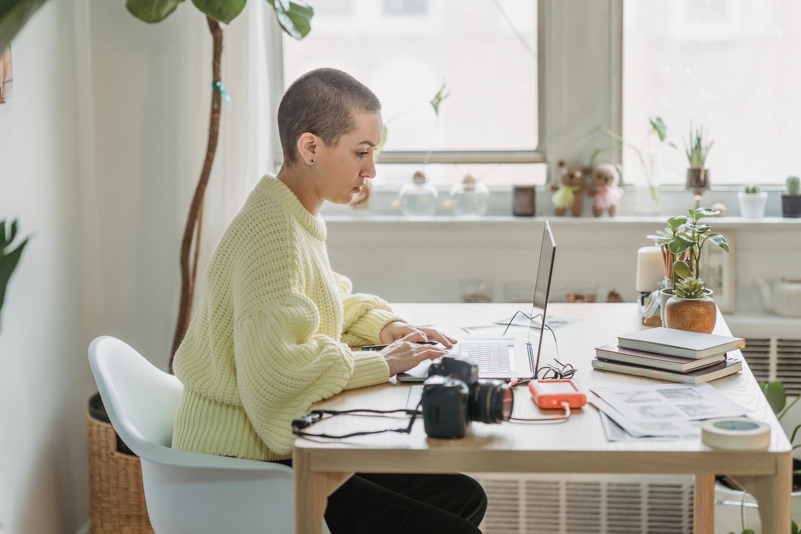 Woman reviewing listings on a laptop at a desk in a bright apartment