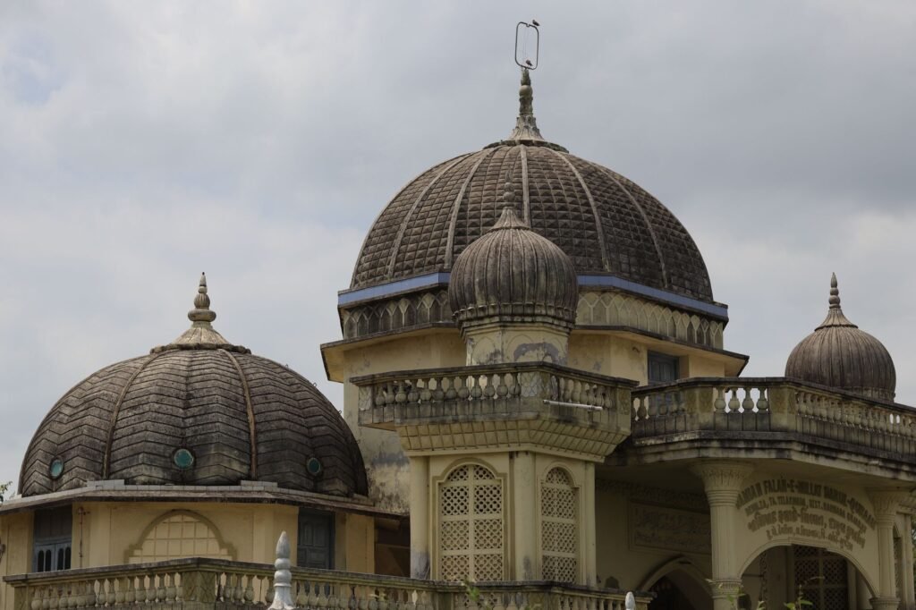 A detailed view of a historic building's domes under a cloudy sky, showcasing intricate design.