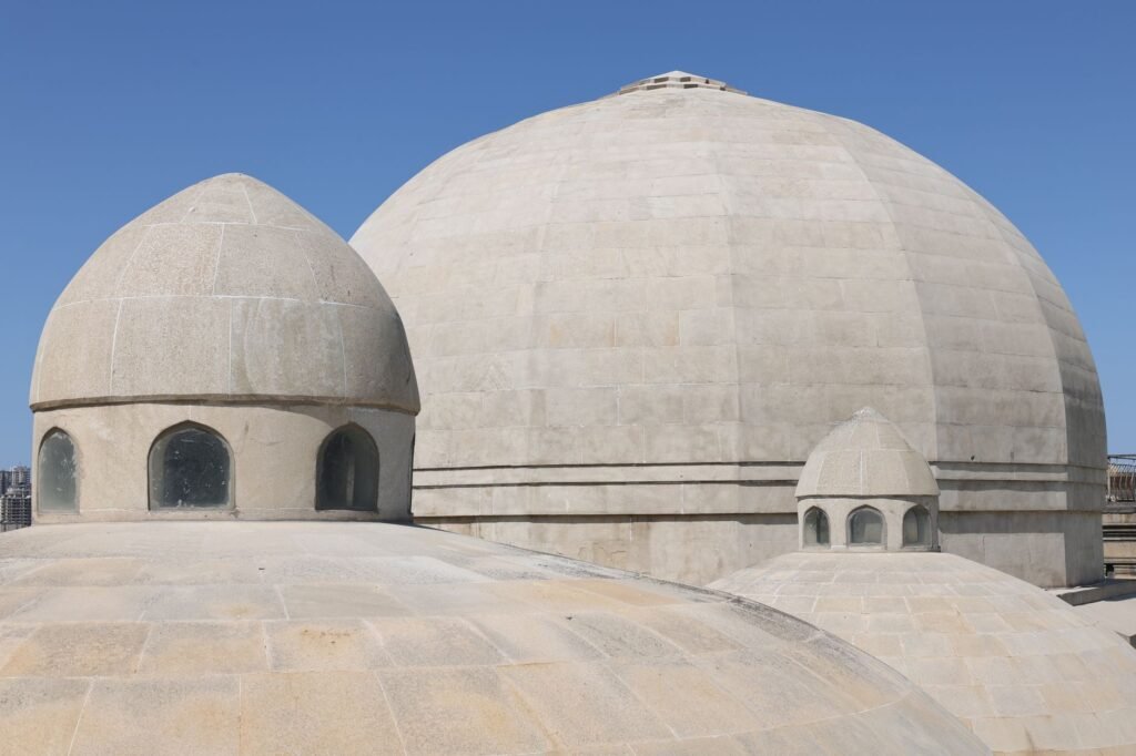 A close-up view of distinctive stone domes against a clear blue sky, showcasing architectural elegance.