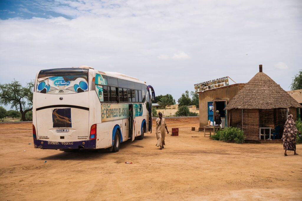 Shared vehicles and motorbikes at a rural transport stop in northern Ghana