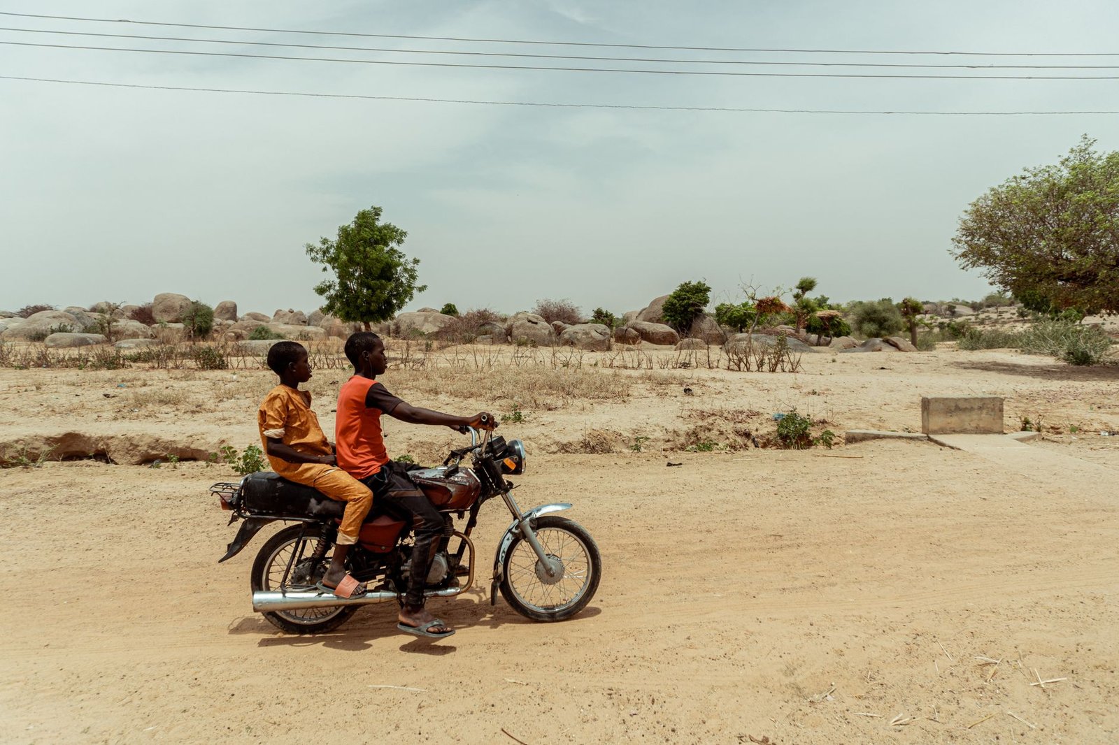 Quiet laterite road through a small northern Ghanaian town at golden hour